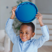 Child holding a blue stainless steel plate above their head with a neutral background