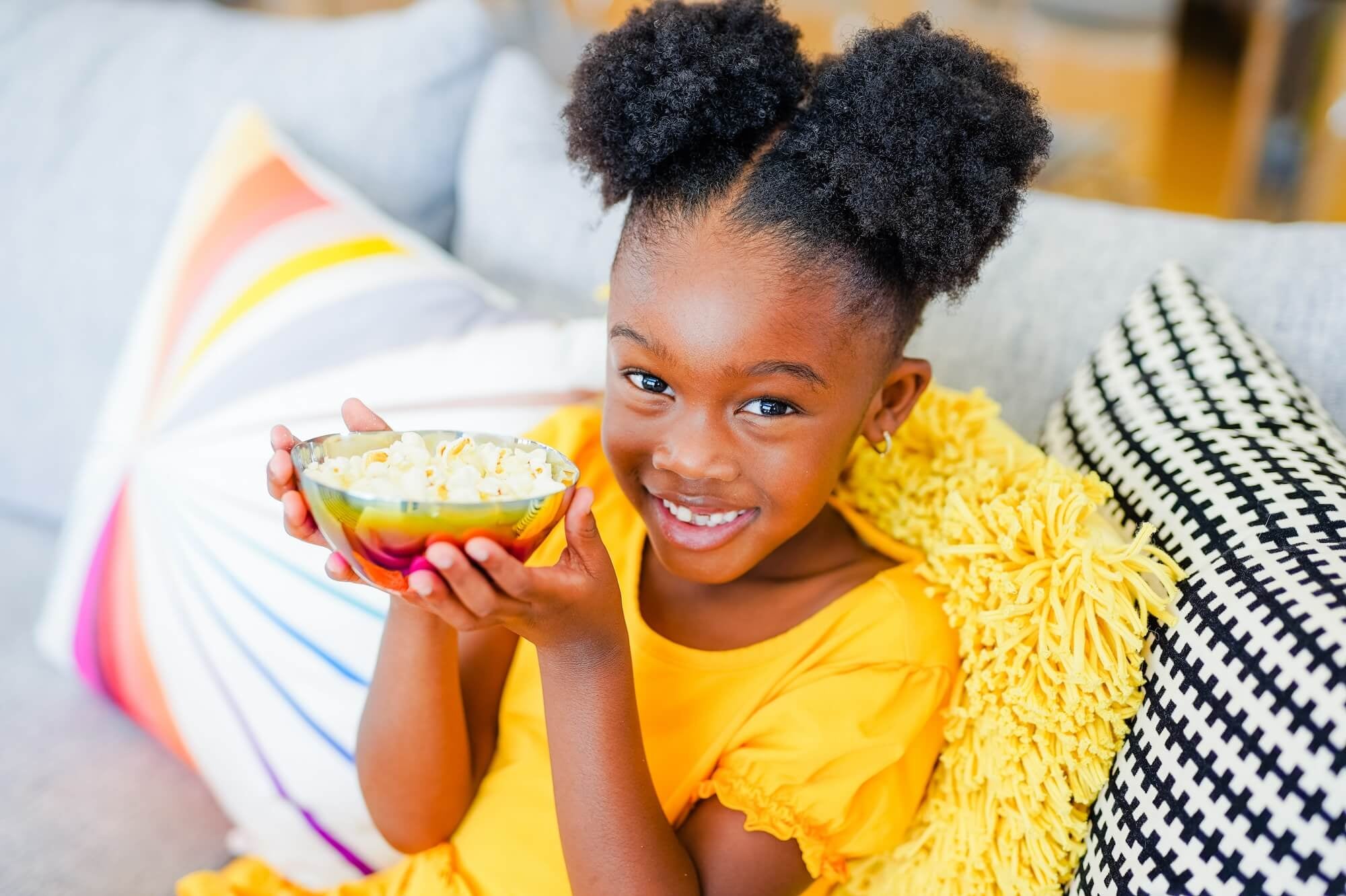 girl with stainless steel bowl full of popcorn