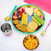 Rainbow Ahimsa stainless steel 9" Purposeful Plate with food (strawberries, blueberries, celery, cheese, crackers) with 8 ounce stainless steel Rainbow Conscious Cup and 8 ounce round bowl with goldfish crackers, and Rainbow Utensil Set (fork and spoon)