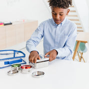 Kid packing lunch with stainless steel square and circle food containers