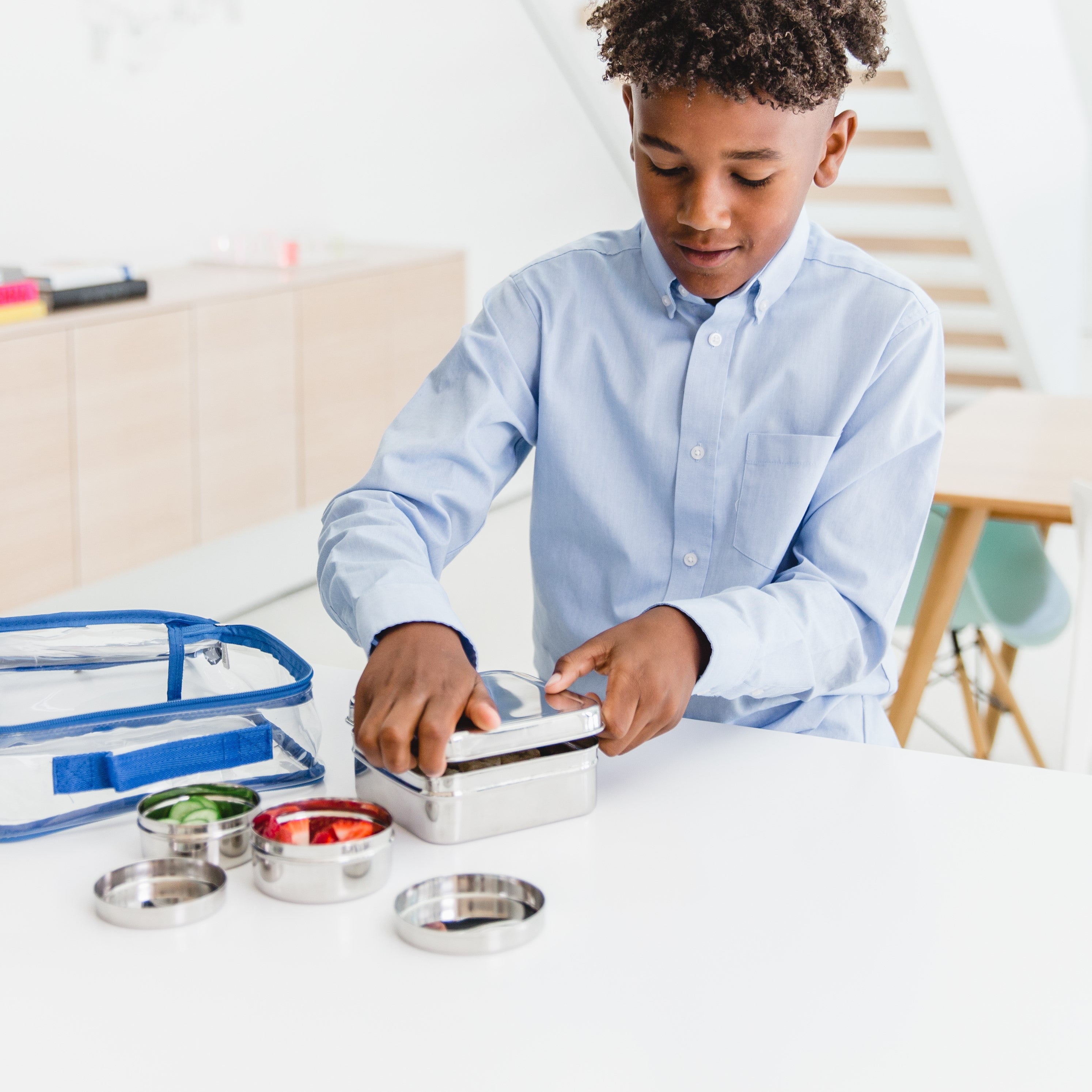 Kid packing lunch with stainless steel square and circle food containers