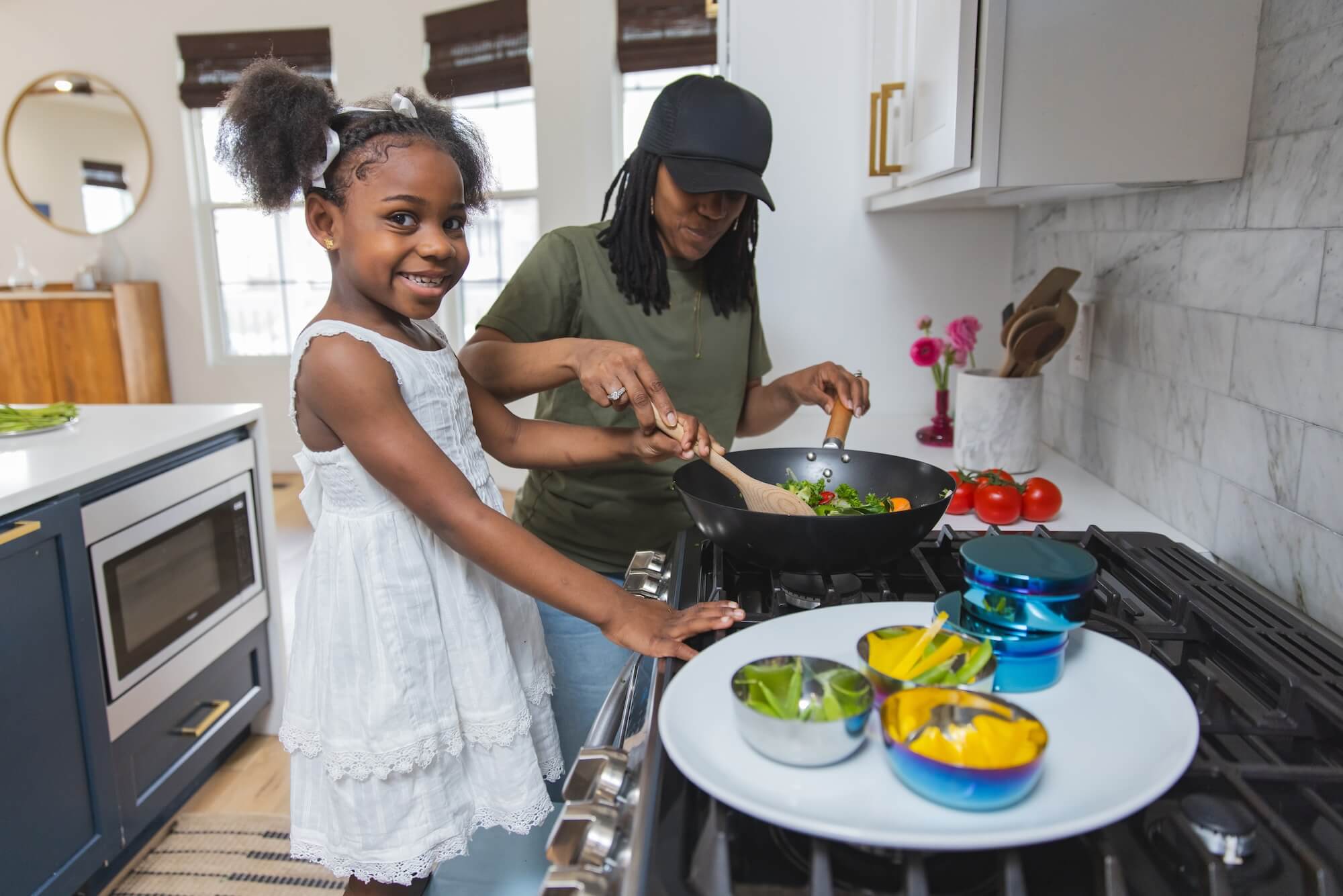 mom and daughter cooking with stainless steel dishes