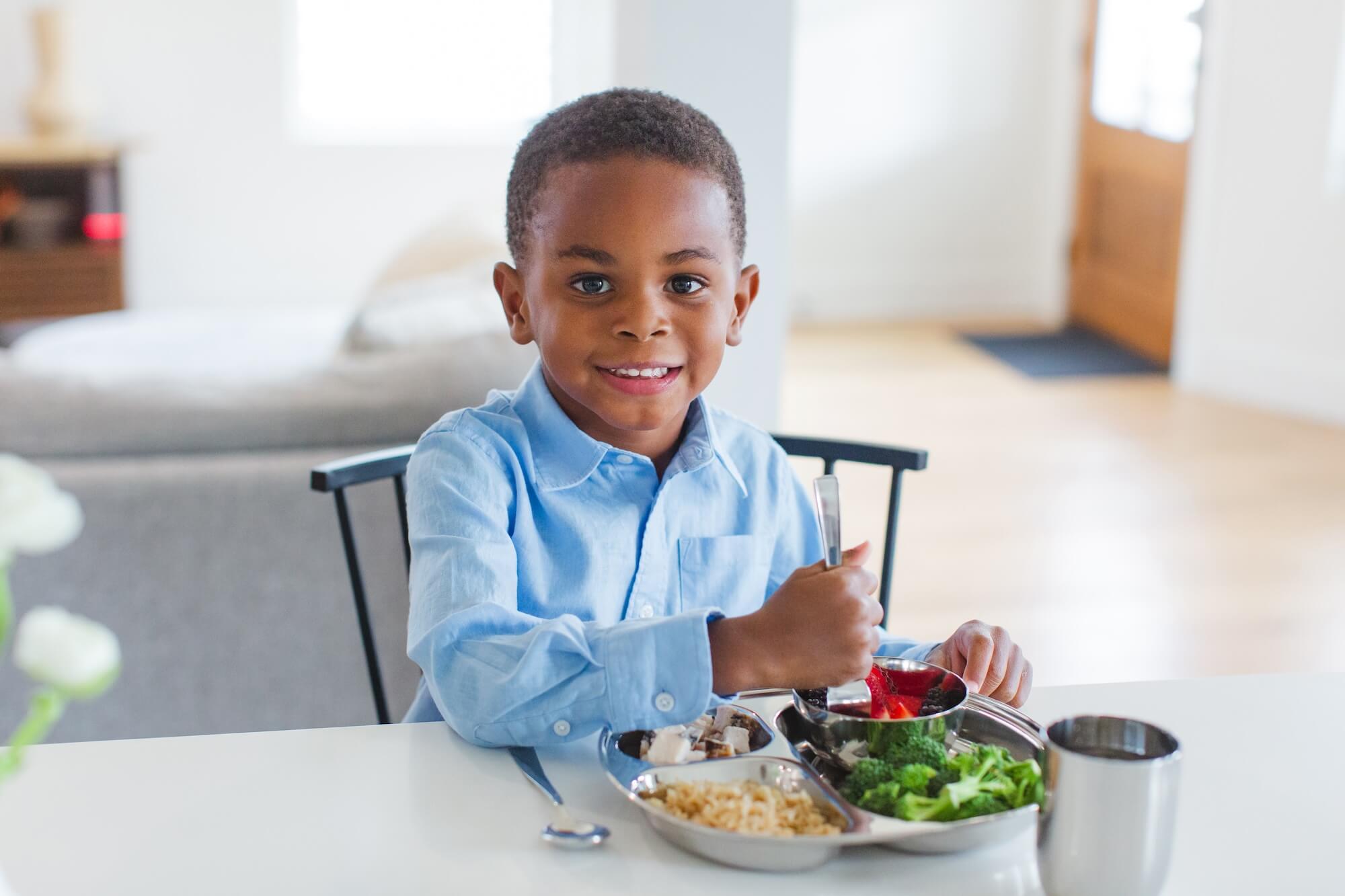 child eating with stainless steel dishes