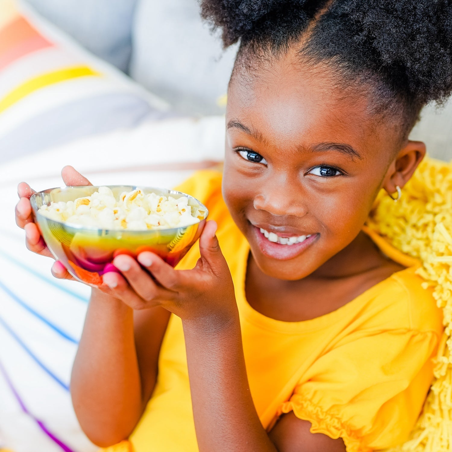 girl with popcorn in stainless steel bowl