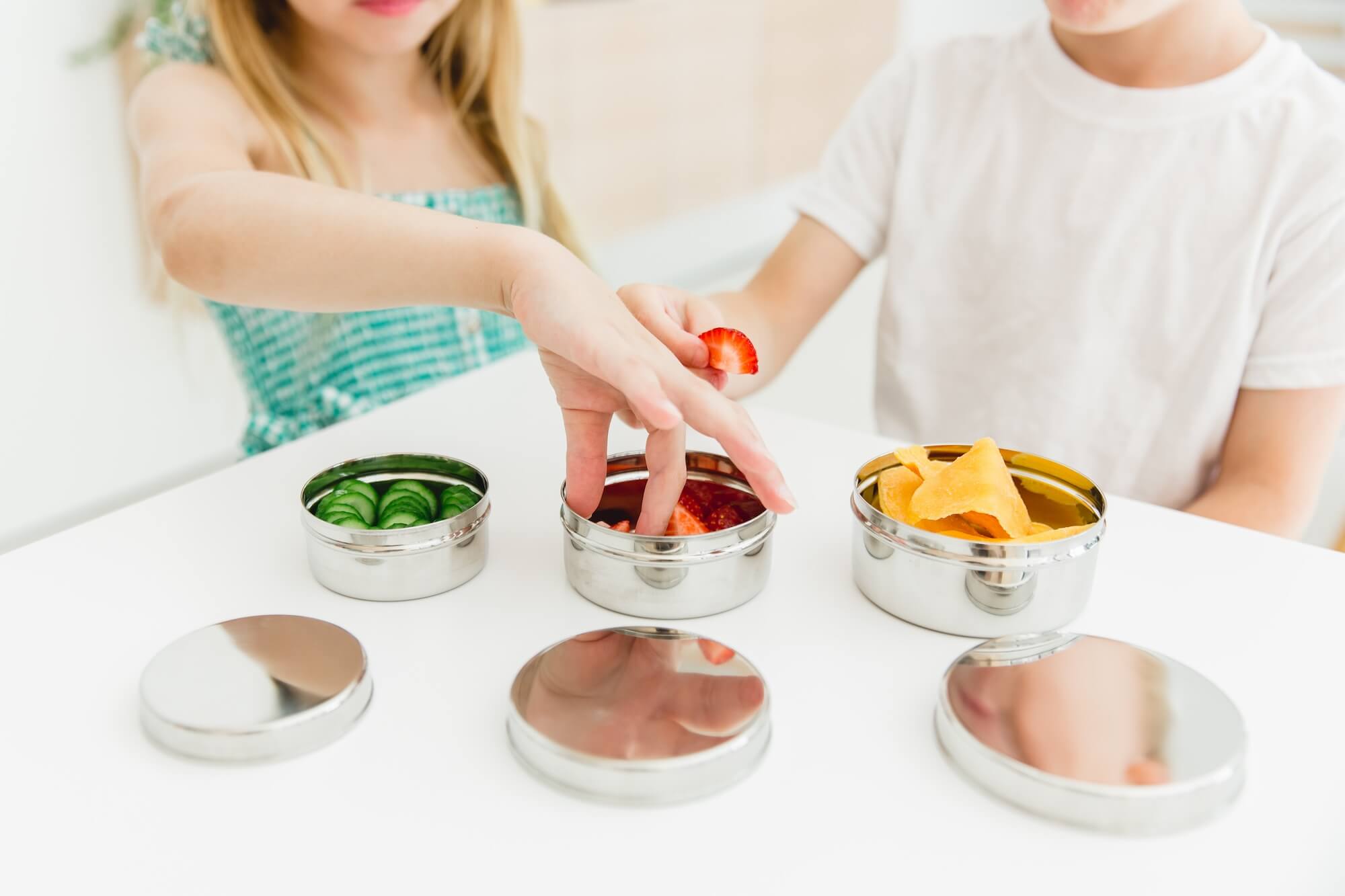 child eating with stainless steel dishes