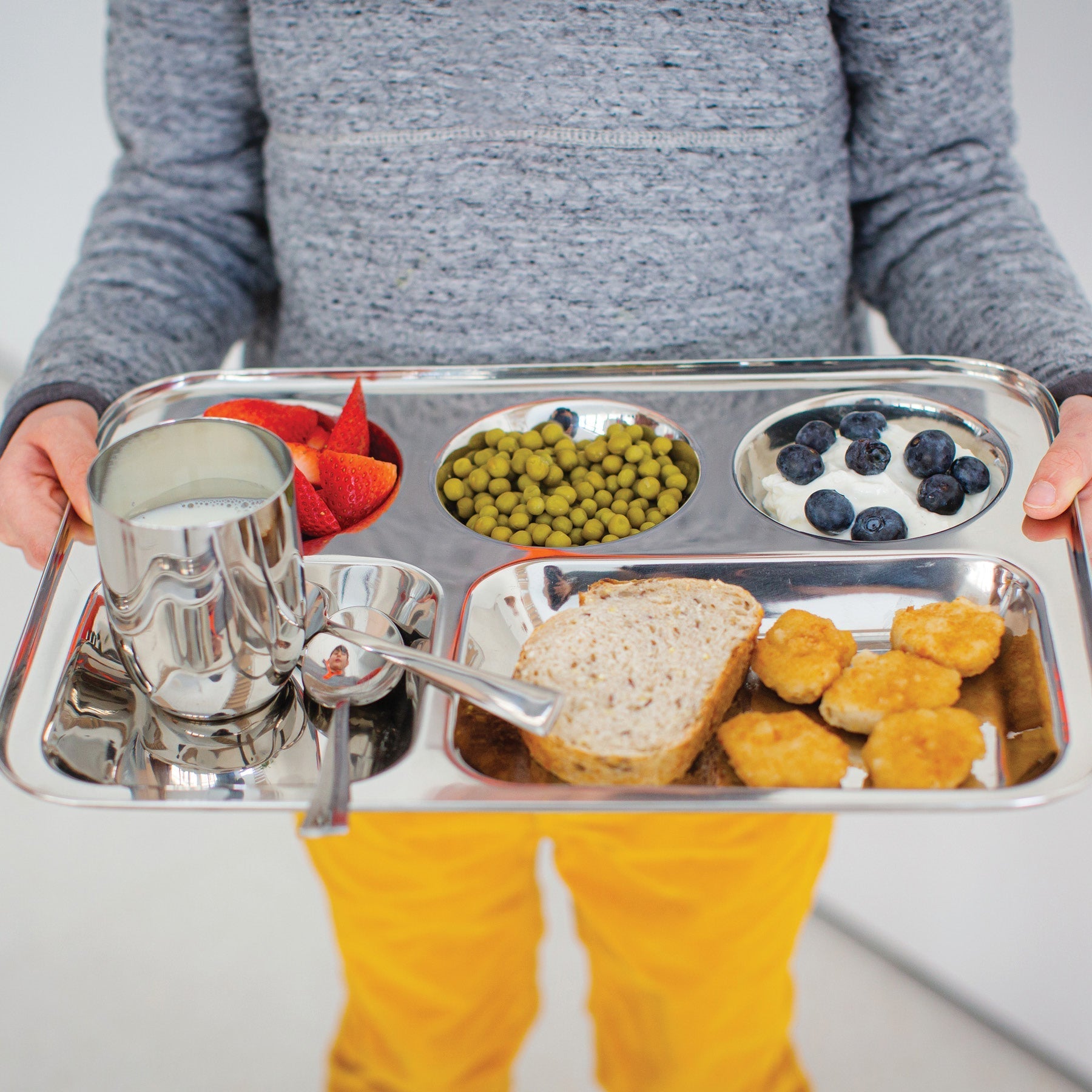 Child with stainless steel cafeteria tray