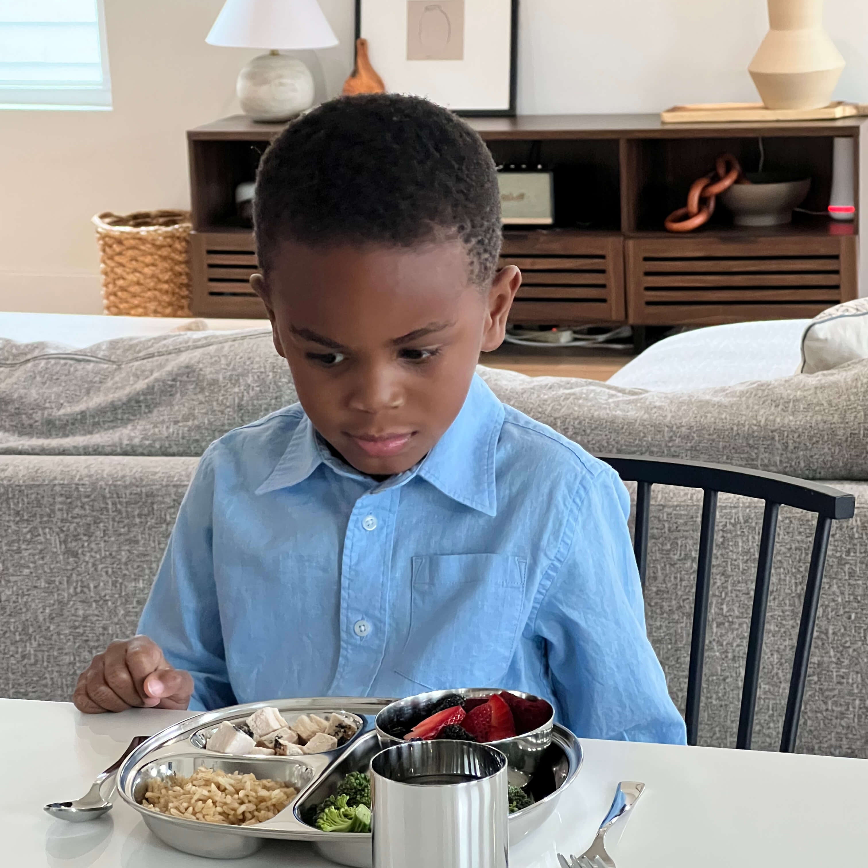 child eating with stainless steel dishes