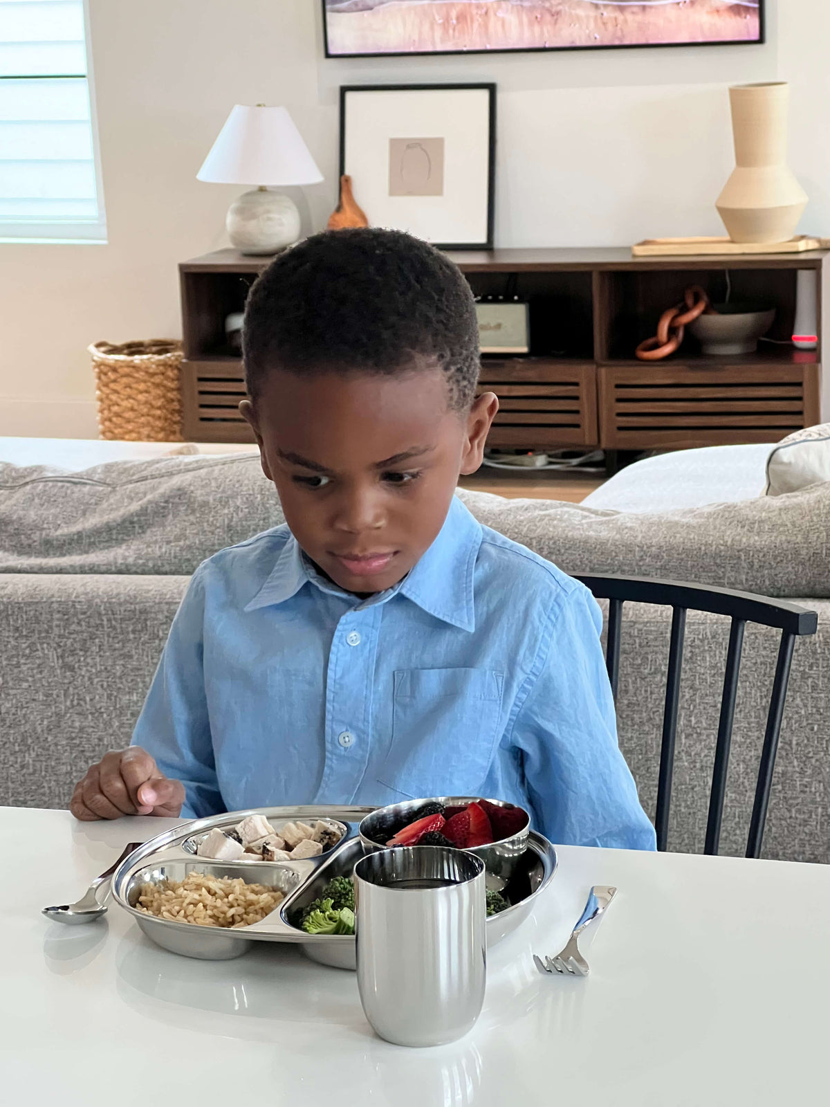 child eating with stainless steel dishes