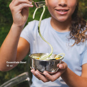 Older girl eating zucchini pasta out of 16 ounce stainless steel bowl