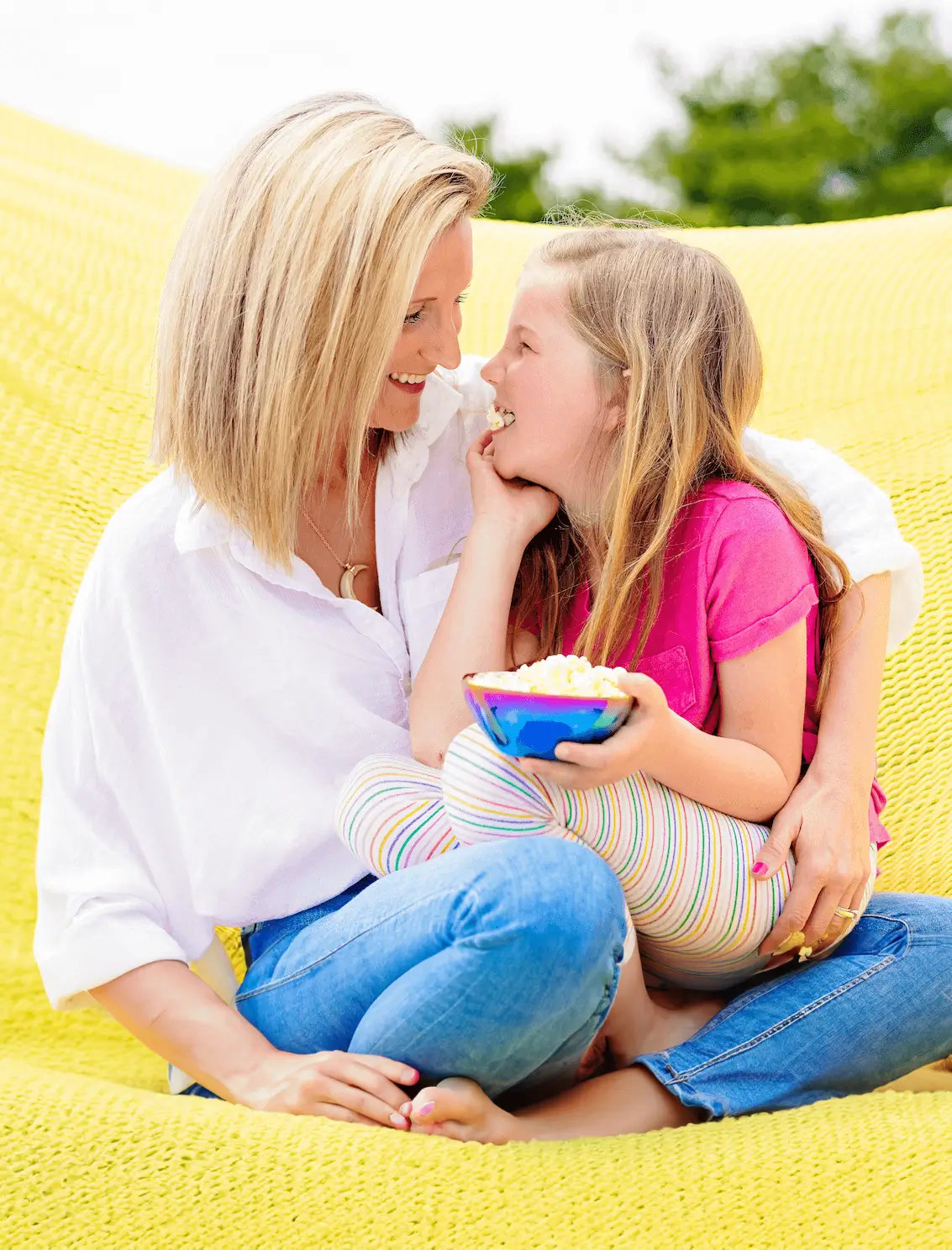 Mom and daughter looking at each other with a stainless steel kids snack bowl