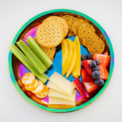 Crackers, celery, mango, strawberries, blueberries, and cheese on a stainless steel plate. Rainbow stainless steel plate for kids, toddlers, and adults