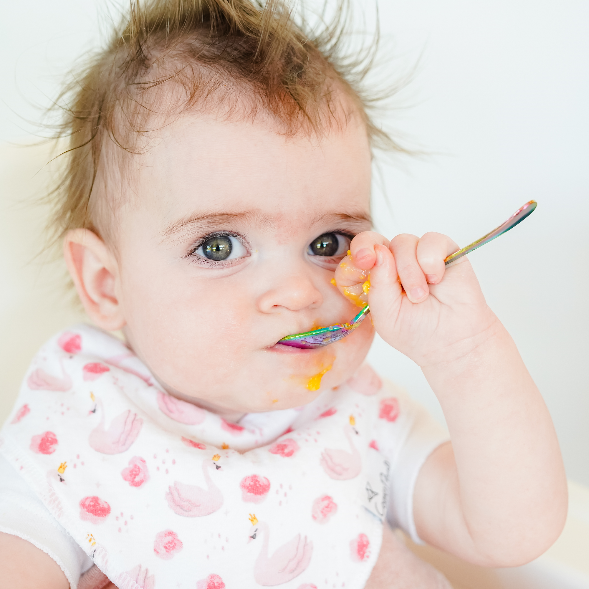 Baby using the starting solids set infant spoon to feed herself, set can be used for traditional feeding or baby led weaning