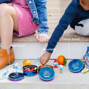Kids reaching for snacks from stainless steel food containers with Smurfs etched on the lids - berries, cucumbers, and tomatoes