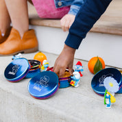 Child's hand reaching for pretzels from blue food stainless steel containers. Blue Large Circle food containers with Smurfette, Papa Smurf, and Classic Smurf etched to the lids.