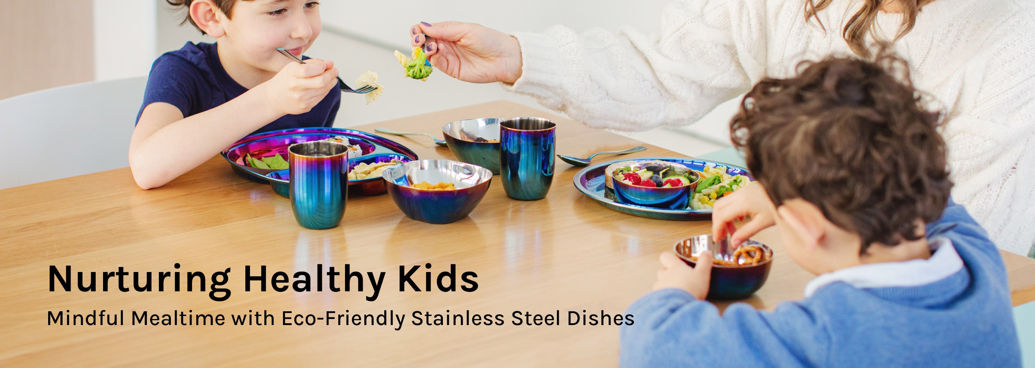 Two young kids eating at the dinner table with their mom using Ahimsa's Iridescent-Blue Mindful Mealtime Sets and 12 oz snack bowls