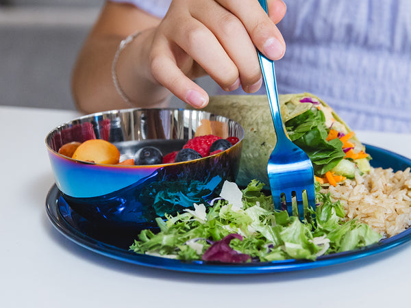 Person eating a meal with salad, rice, and fruit on a blue stainless steel plate, blue stainless steel bowl (8 ounces or 1 cup), and stainless steel fork.