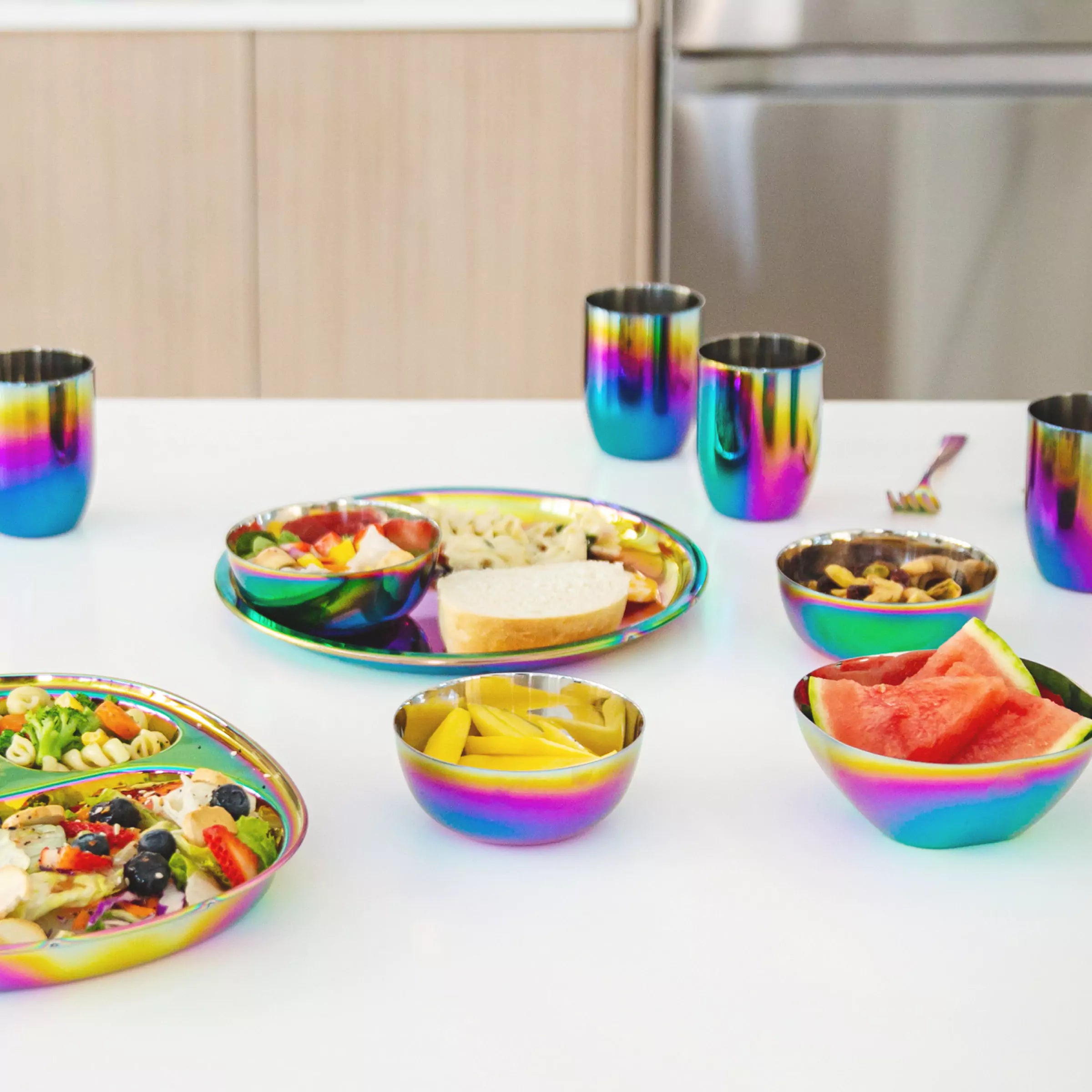 Bright Rainbow dishes on a table including Ahimsa's Purposeful Plate, Conscious Cups (8 ounces), Balanced Bites Compartment Plate, and Smart Snacking Bowls (12 ounces)